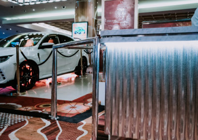 Example of sheet metal fabrication featuring a custom aluminium piece displayed beside a car