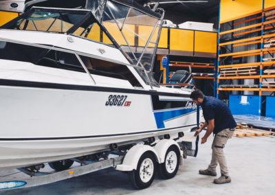 Specialist inspecting sheet metal boat hulls before delivering the final product